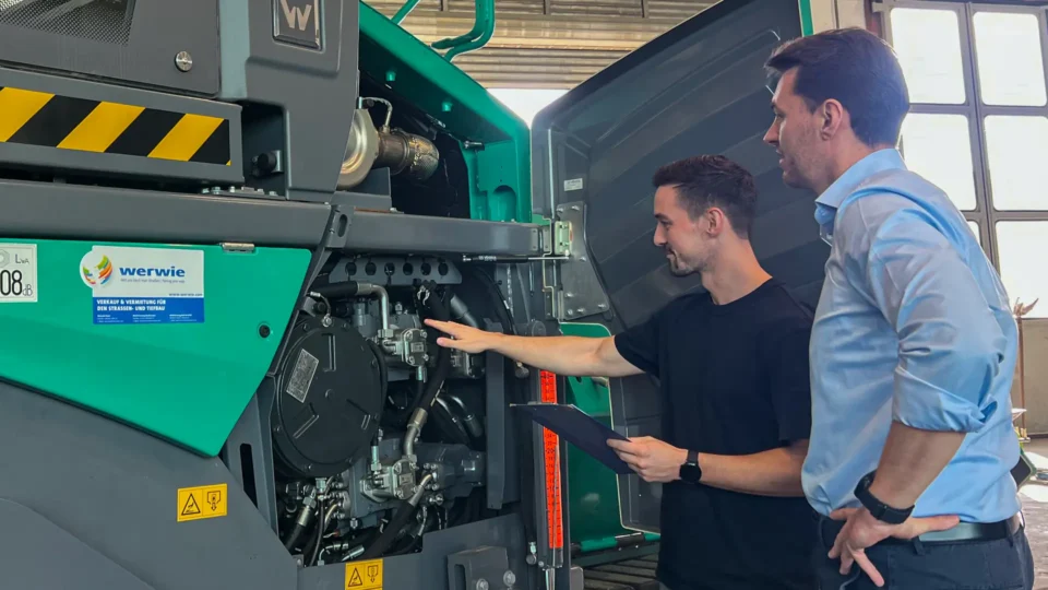 Detailprüfung im Motorraum: werwie Experten beim gründlichen Technikcheck während der Baumaschinen-Kaufberatung.