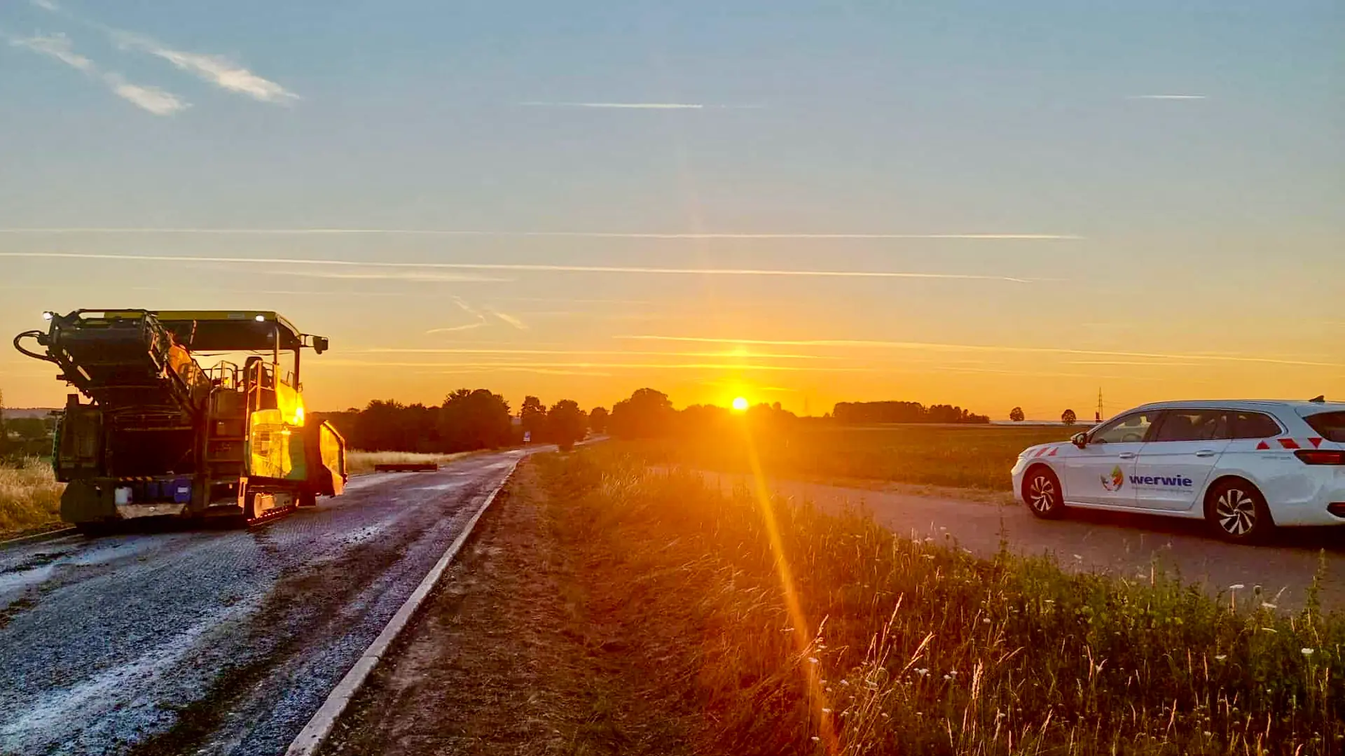 Baumaschine bei Straßenbauarbeiten im Abendlicht auf der Autobahn