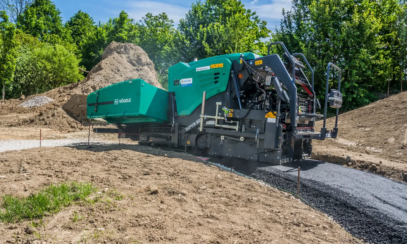 Kompakter Vögele Mini-Class-Asphaltfertiger beim präzisen Asphalteinbau auf einem schmalen Wirtschaftsweg.