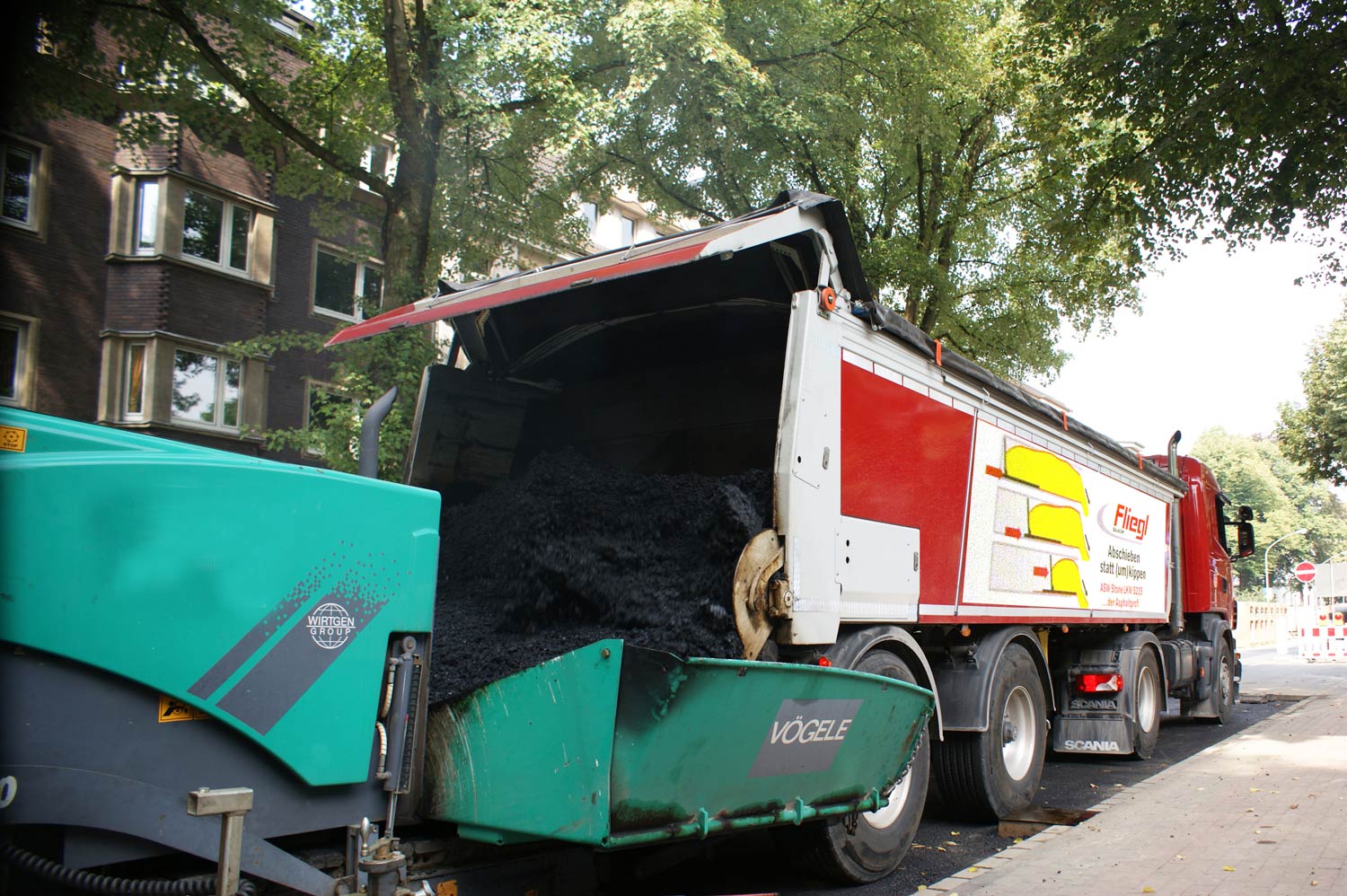 Thermoisolierte Abschiebemulde schiebt Asphaltgut in Beschicker
